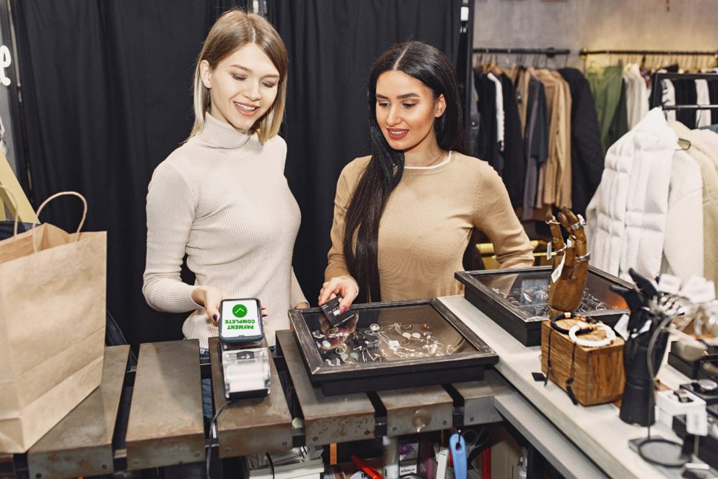 Ladies paying at register with Mobile Payment App in jewelry store