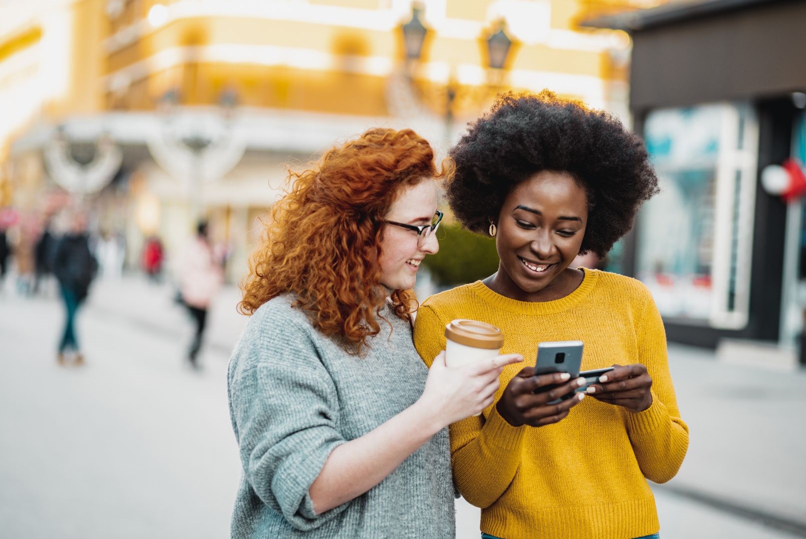 Women drinking coffee, looking at an app - Targeted and Personalized Marketing with Loyalty Programs